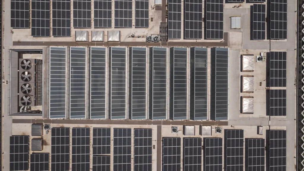 Arreglo de paneles solares sobre un techo industrial visto desde arriba