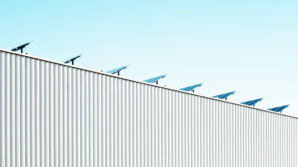 Borde del techo de una nave con paneles solares contra el cielo