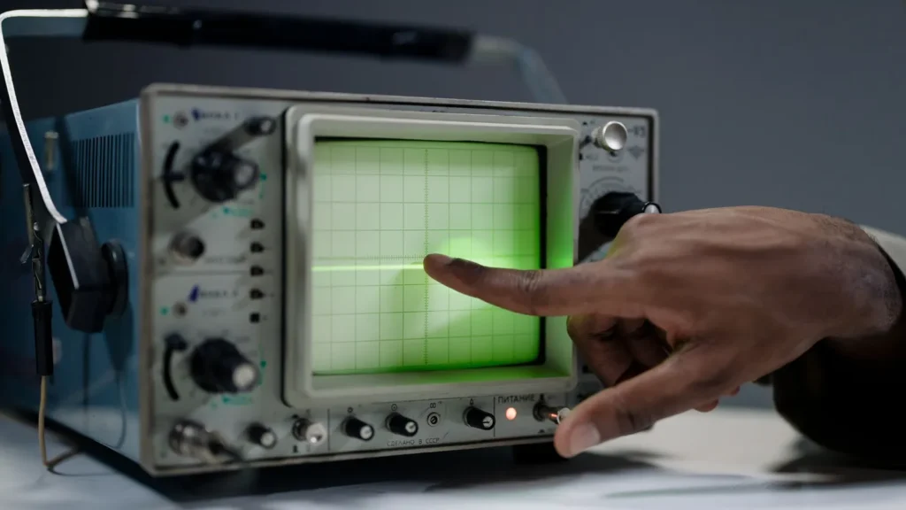 Técnico señalando la pantalla de un osciloscopio