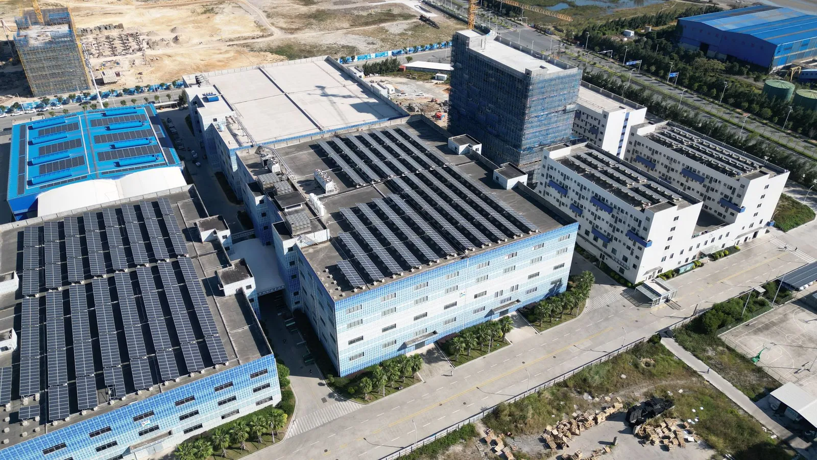 Planta industrial con paneles solares sobre el techo, vista aérea