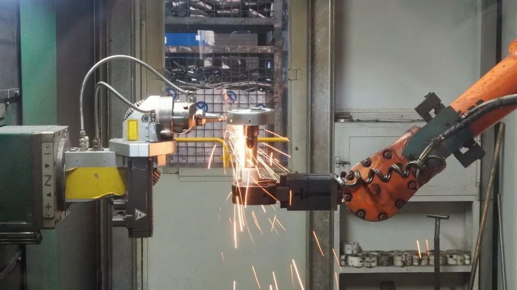 Robot industrial soldando una pieza entre chispas