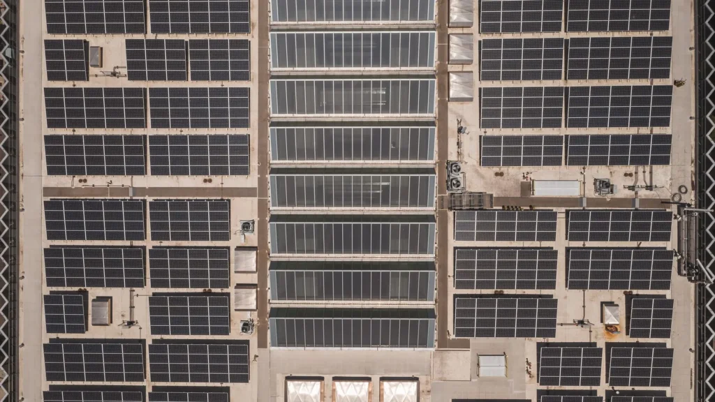 Techo industrial cubierto con filas de paneles solares visto desde arriba