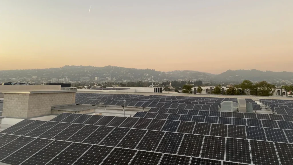Techo cubierto de paneles solares al atardecer, con montañas al fondo